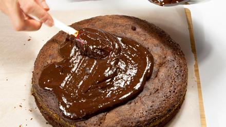 Kuumenna kerma kattilassa. Lisää joukkoon paloiteltu suklaa ja margariini. Sekoita, kunnes kuorrutus on tasaista. Anna hieman jäähtyä ja kuorruta kakku. Koristele ananaskirsikoilla.