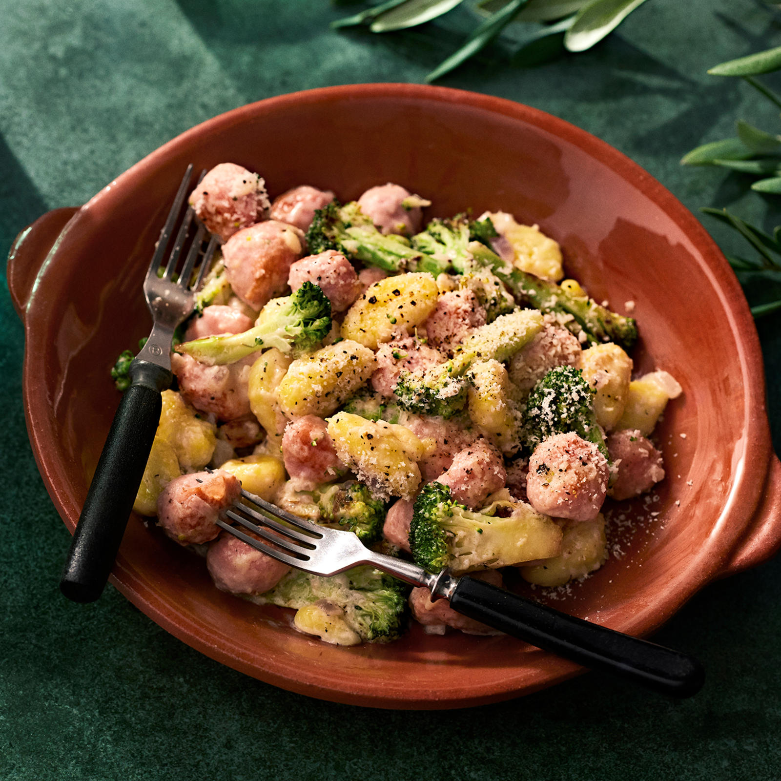 Siskonmakkara-gnocchipannu lautasella, jossa kaksi haarukkaa.