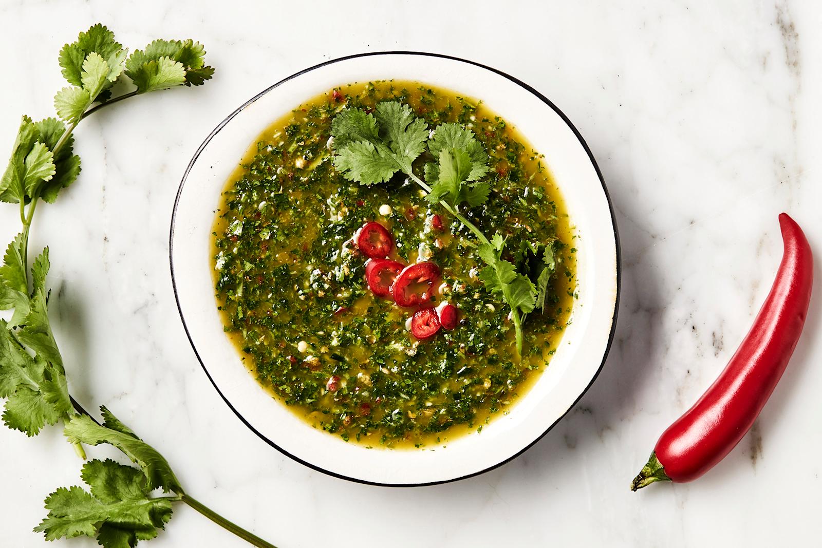Chimichurri laakeassa kulhossa chiliviipaleilla ja korianterilla koristeltuna.