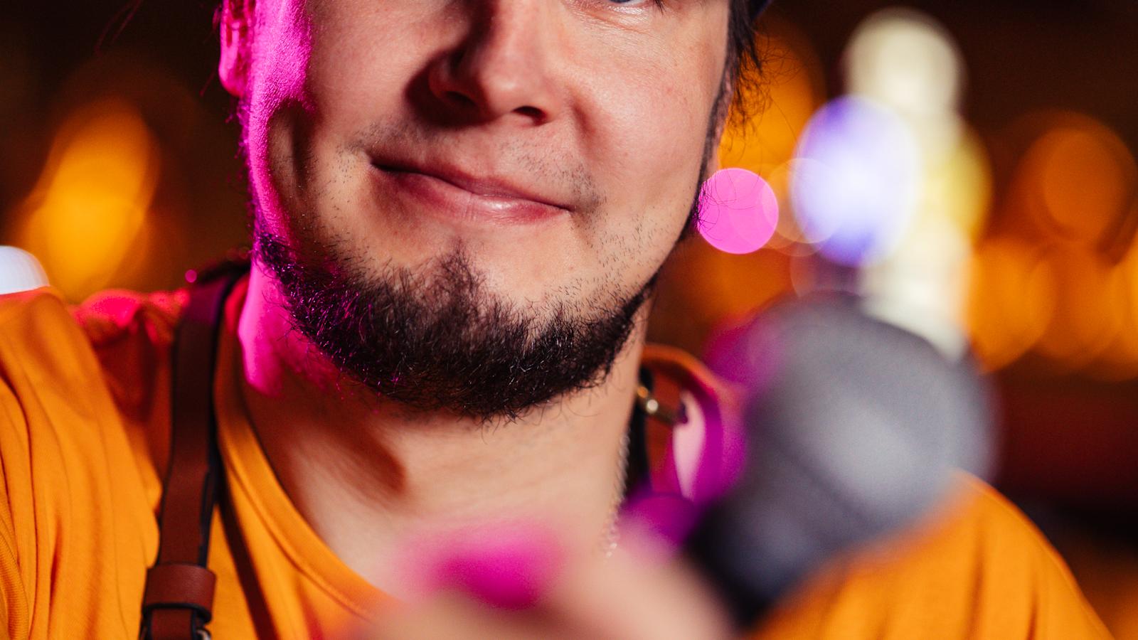 Karaokeisäntä Tomi Paakkunainen mikrofoni kädessä.