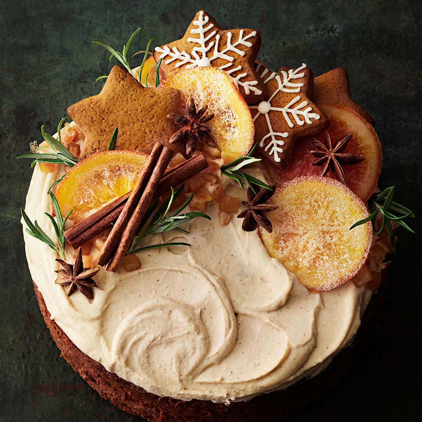 Englantilainen hedelmäkakku tuorejuustovaahdolla kuorrutettuna. Kakku on koristeltu kanelitangoilla, kandeeratuilla appelsiineilla, piparkakuilla, tähtianiksilla ja rosmariinitupsuilla.