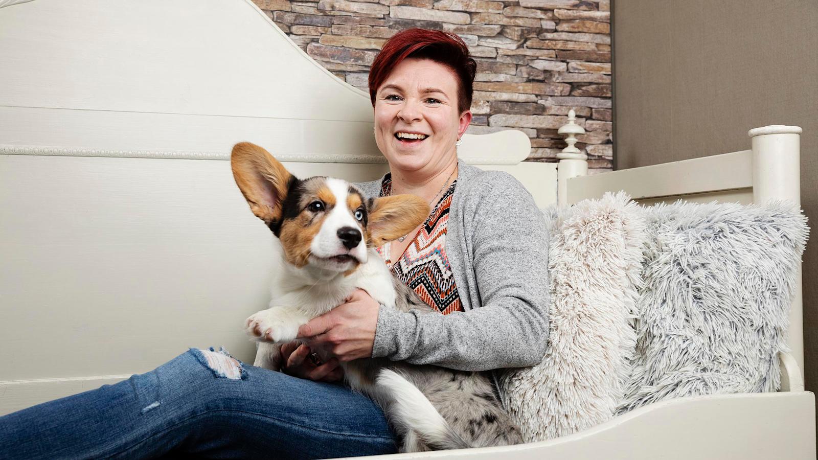 Avioeron kokenut Elina Sandberg ja koira istuvat sohvalla.
