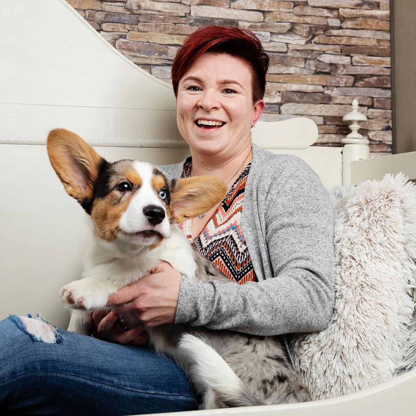 Avioeron kokenut Elina Sandberg ja koira istuvat sohvalla.