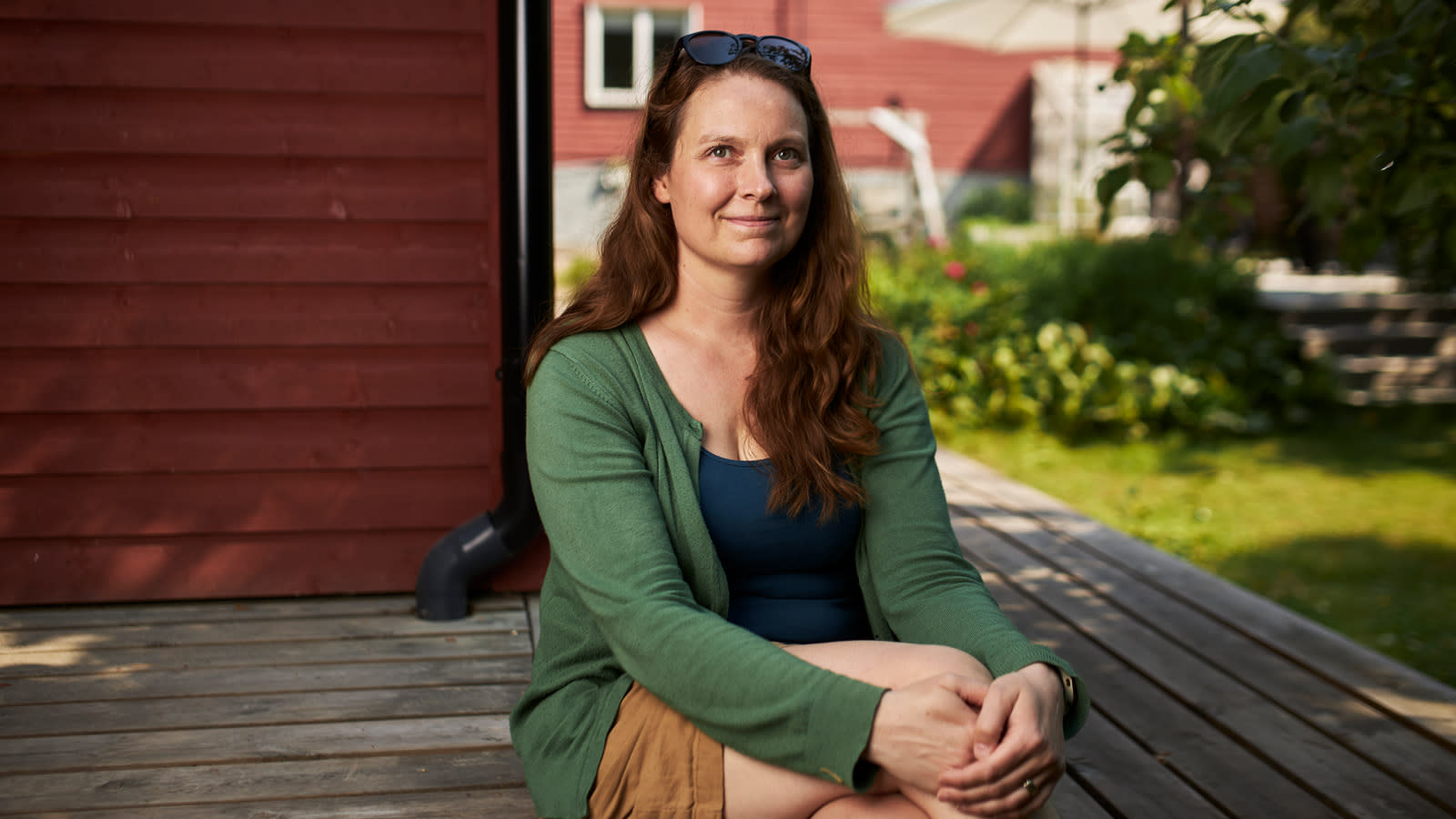 Elina Kyytsönen istumassa omakotitalonsa terassin kulmalla.