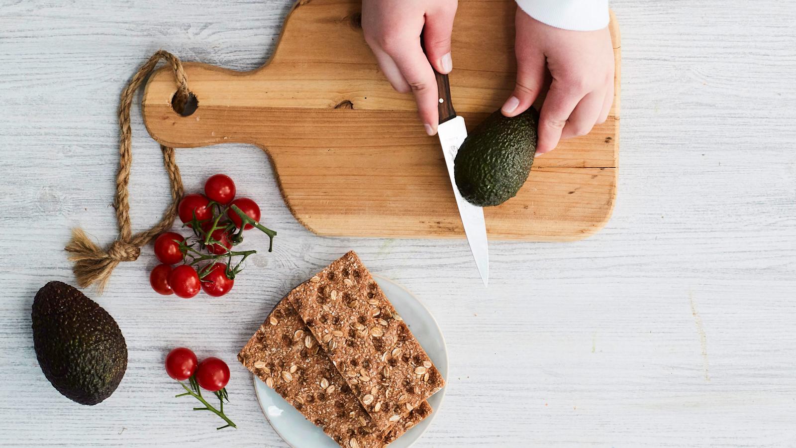 Leikkaa avokado halki niin, että veitsen terä on keskellä olevaa kiveä vasten. Tartu avokadon puolikkaisiin molemmilla käsillä ja käännä, niin puolikkaat irtoavat toisistaan.