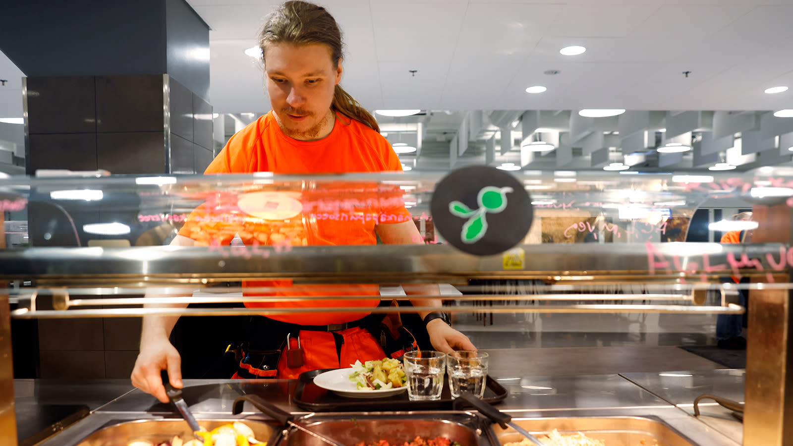 Mies ottaa ruokalinjastolta ruokaa