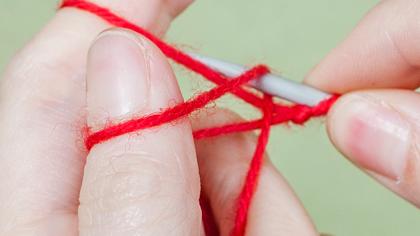 Silmukoiden luominen 2: Koukkaa etusormea kiertävä lanka puikolle.