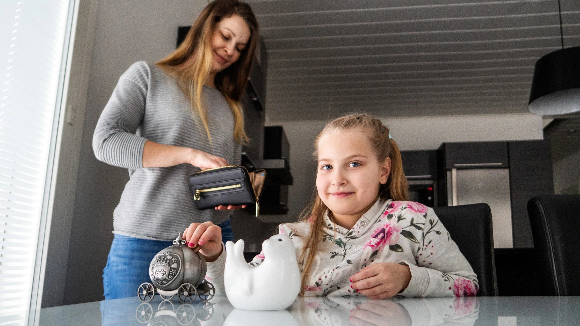 Rahankäyttöä opettelevalla Mila Halmisella on kaksi säästöpossua.
