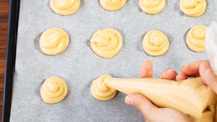 Nosta tai pursota taikinasta teelusikan kokoisia nokareita leivinpaperoidulle uunipellille. Paista 200-asteisen uunin keskiosassa noin 20 minuuttia. Älä avaa uunin luukkua paistamisen aikana.
