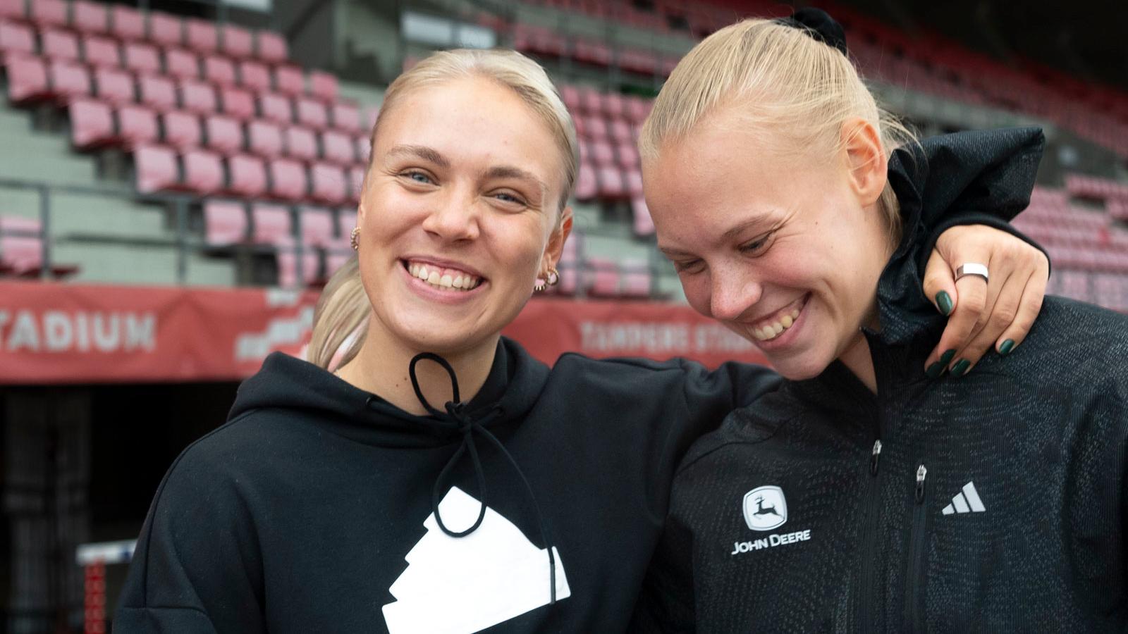 Yleisurheilijat Vilma Itälinna ja Saga Vanninen yhteiskuvassa. Vilman käsi on Sagan hartioilla. Molemmat nauravat.