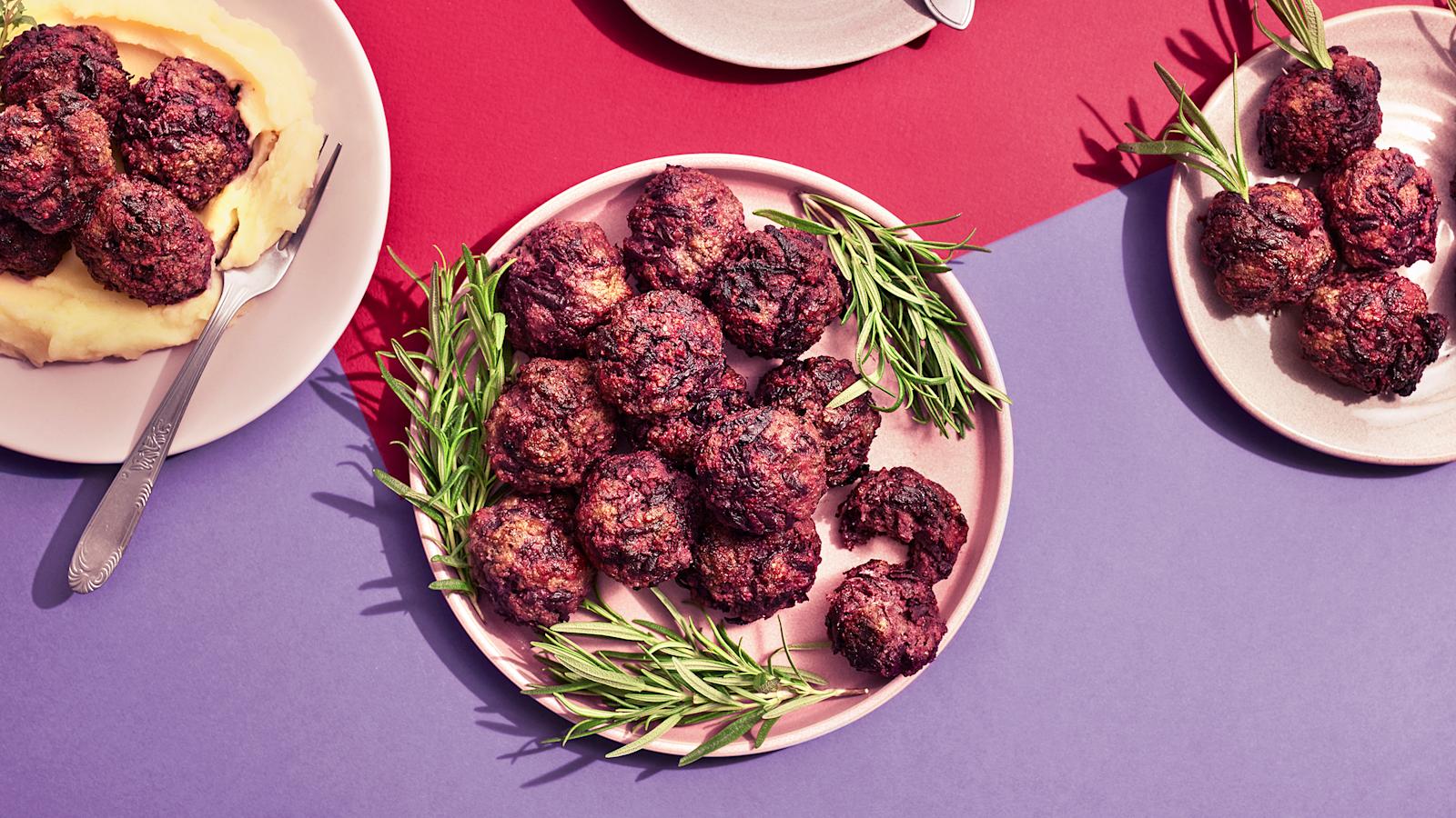 Lindströmin lihapullia lautasella rosmariinin oksilla koristeltuna. Vieressä lautanen, jossa perunamuusia, lihapullia ja haarukka sekä pienempi lautanen, jossa pelkkiä lihapullia.