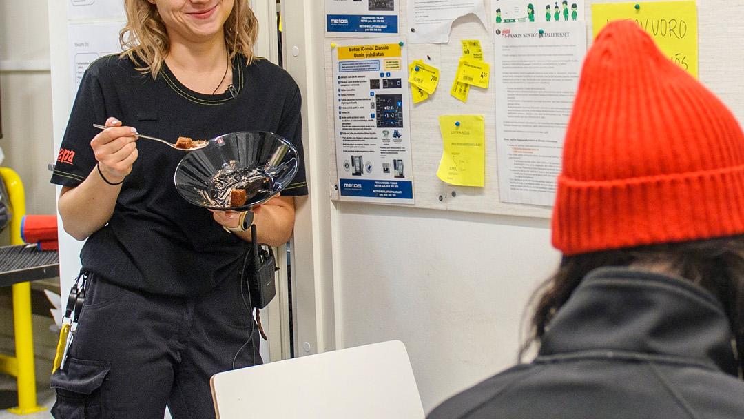 Kati Kuuliainen syö lounasta taukotilassa työkaverinsa kanssa.