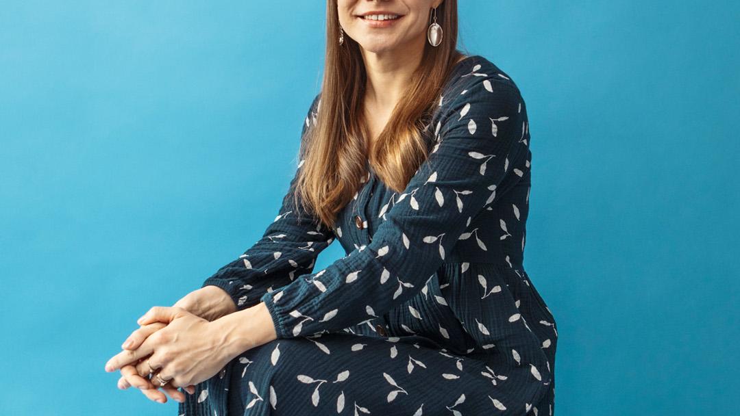 Laura Hendry istuu hymyillen jakkaralla.