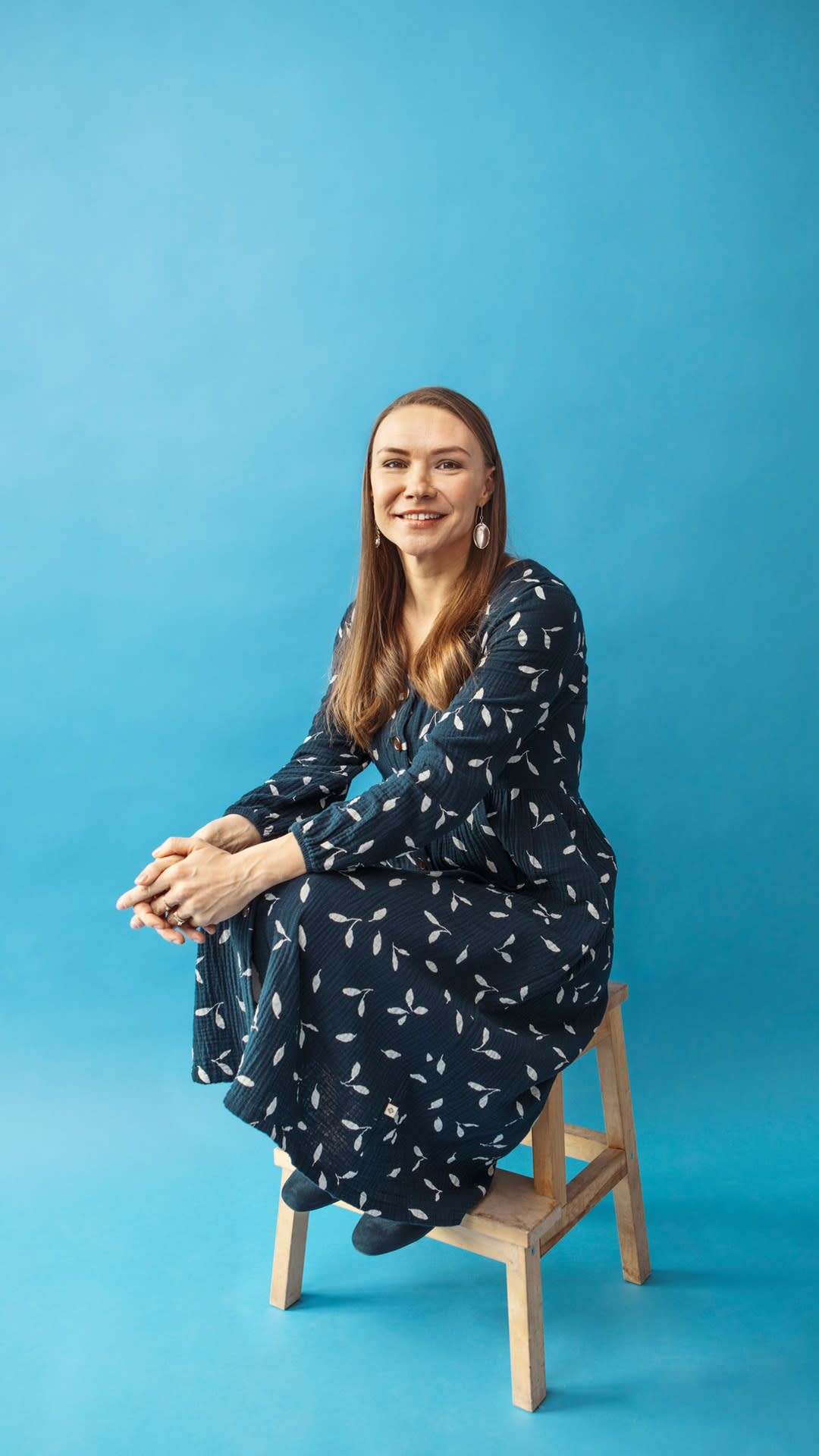 Laura Hendry istuu hymyillen jakkaralla.