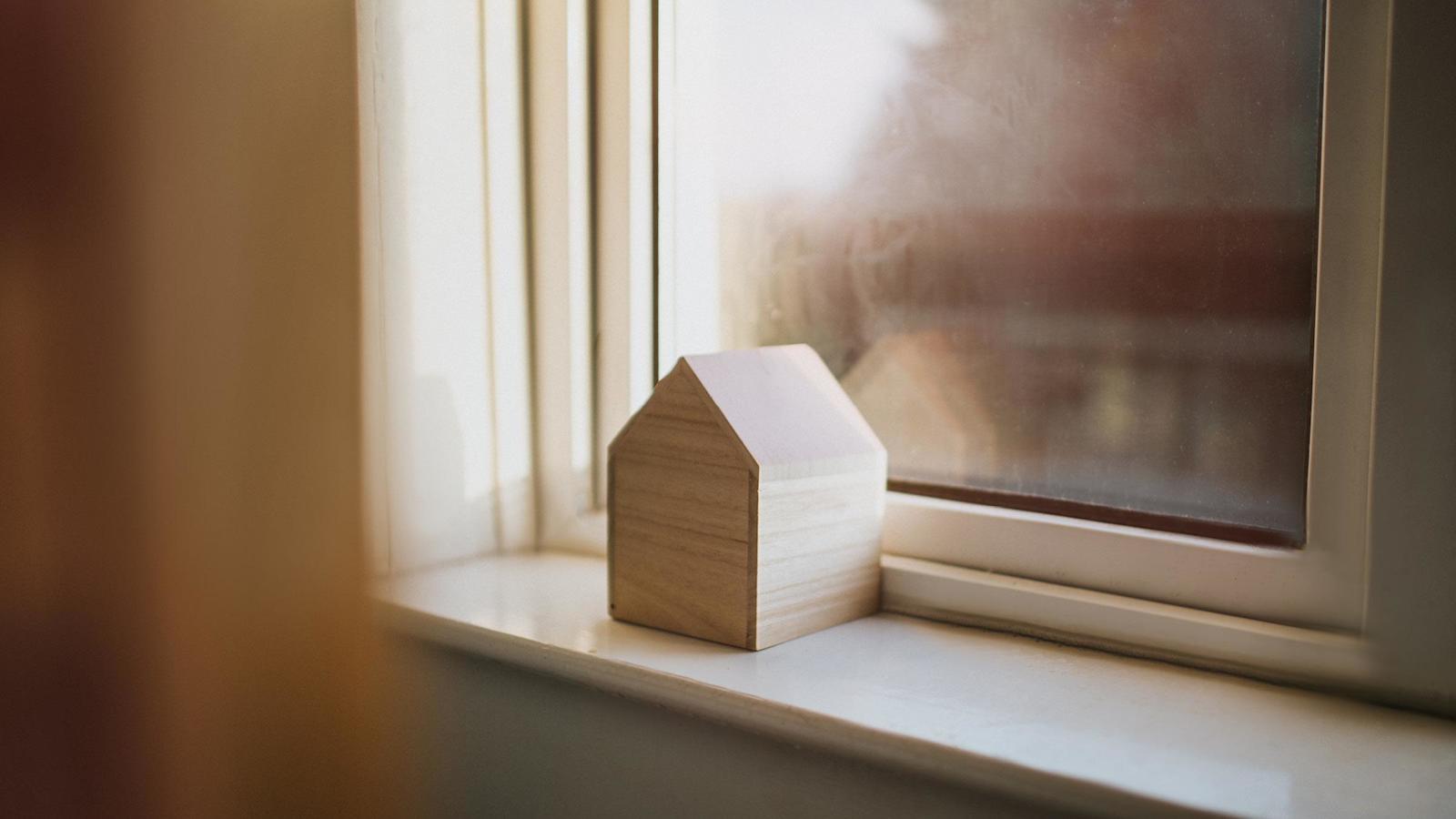 Pieni koristepuutalo ikkunalaudalla