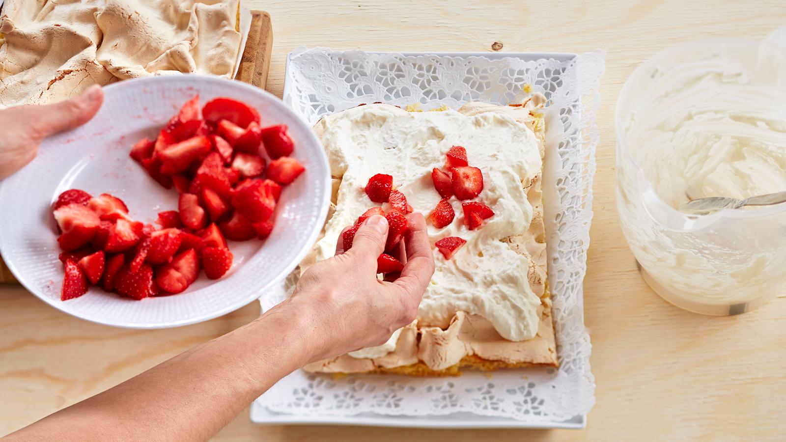 Nosta toinen kakkulevyistä tarjoiluastiaan. Levitä päälle kerma-rahkaseos ja puolet mansikoista.