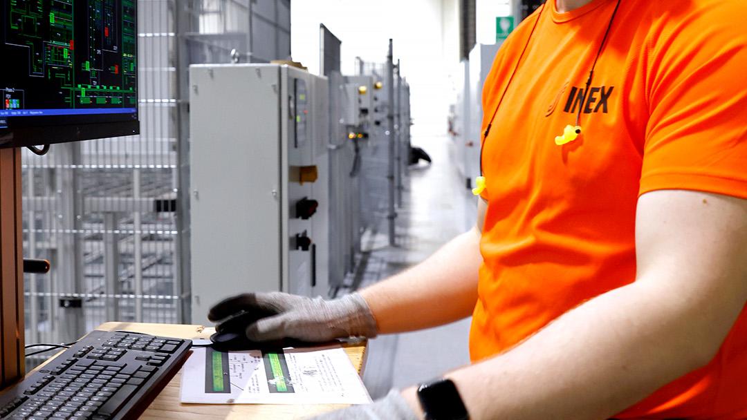 Mies tietokoneella logistiikkakeskuksessa