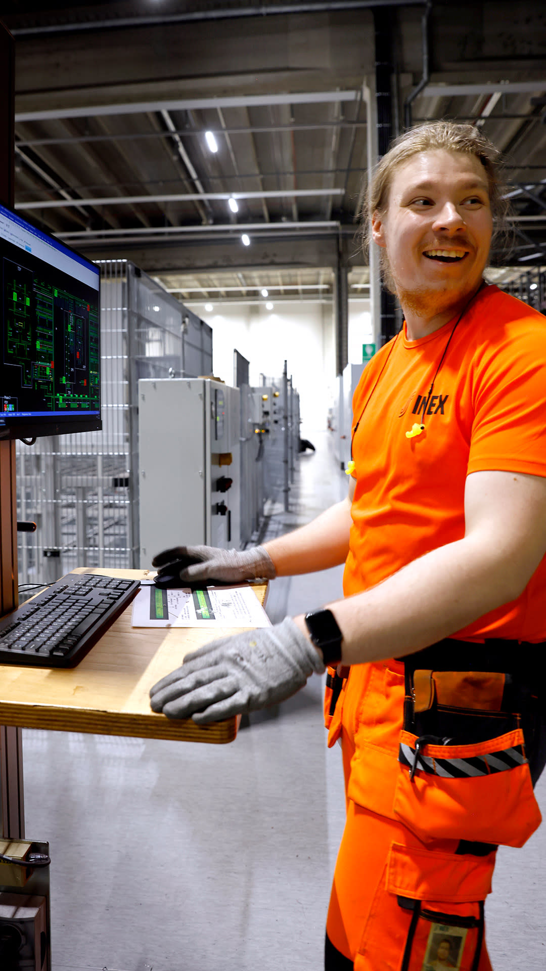Mies tietokoneella logistiikkakeskuksessa