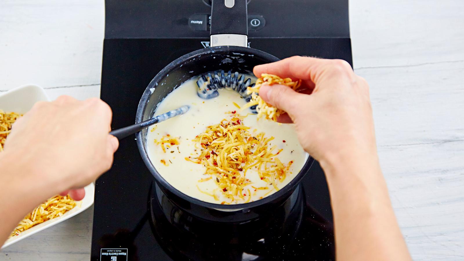 Valmista juustokastike. Sulata rasva kattilassa ja lisää jauhot. Anna kiehahtaa. Lisää maito ja sekoita tasaiseksi. Keitä sekoittaen kunnes kastike sakenee. Sekoita joukkoon osa juustoraasteesta.