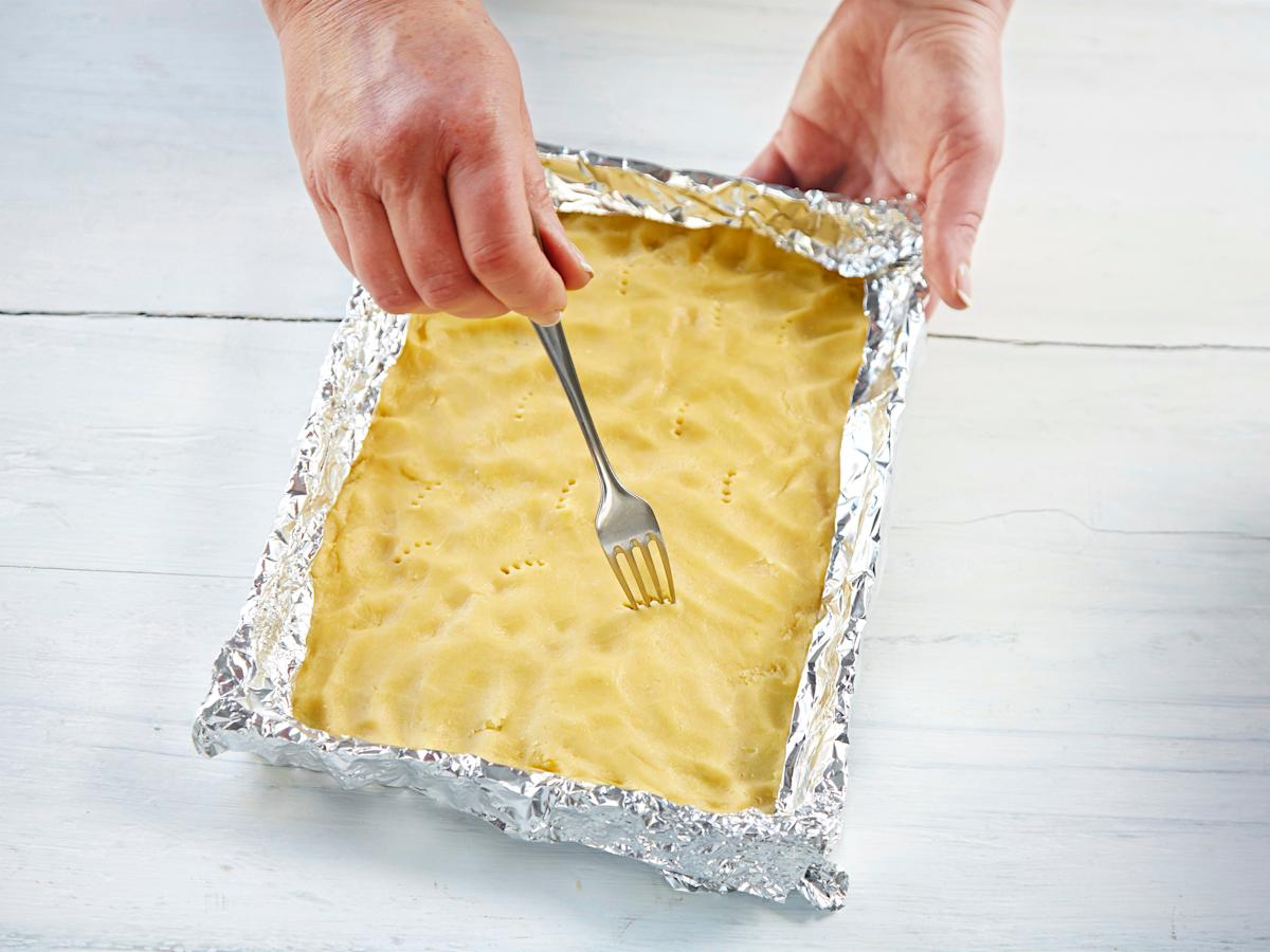 Peitä irtopohjavuoan (halk. n. 22 cm) pohja leivinpaperilla. Kauli taikina vuokaan sopivaksi levyksi. Nosta levy vuokaan ja rullaa kaulimella varovasti ylimääräinen taikina pois. Peitä piiraan reunat kaksinkertaisilla foliosuikaleilla, etteivät ne valu...