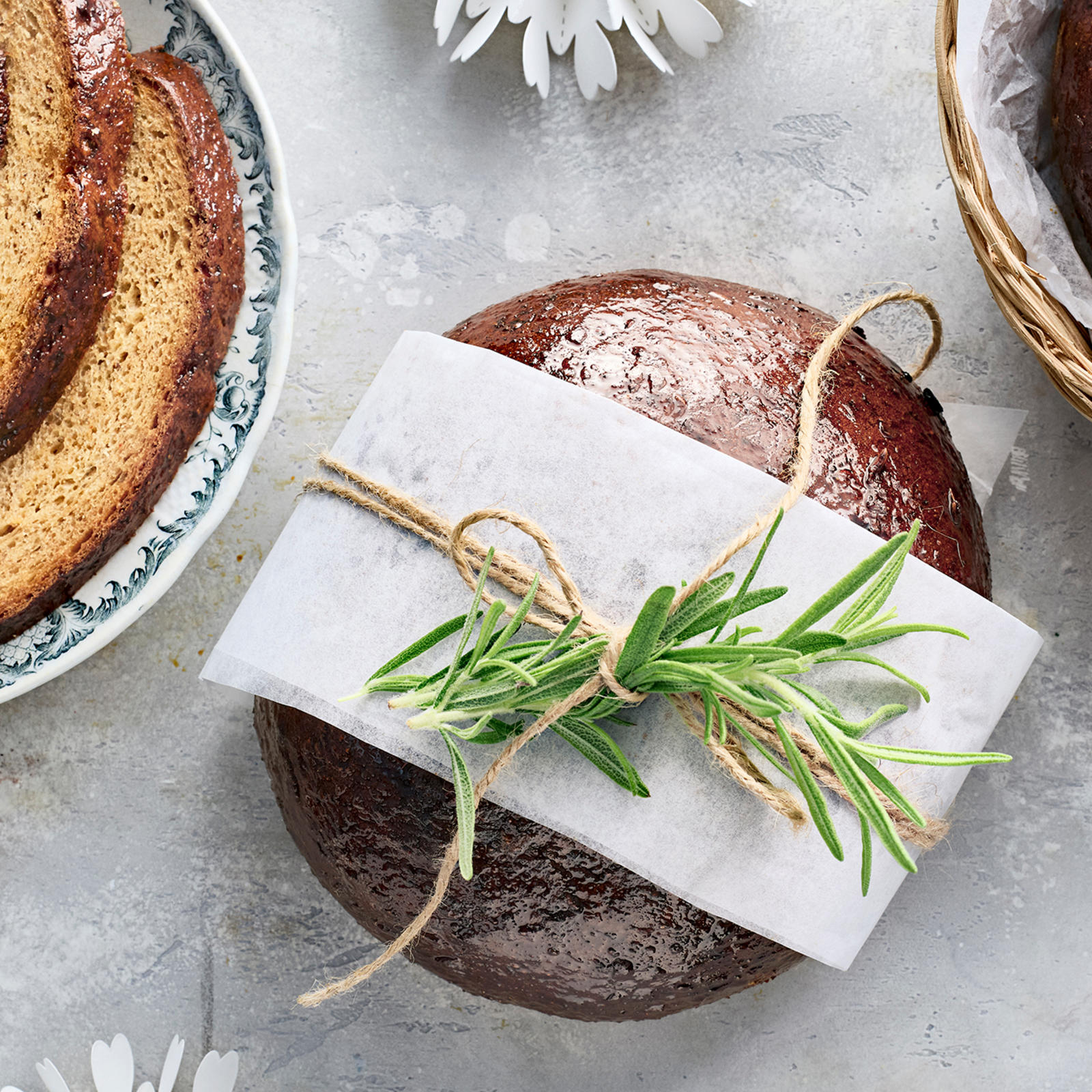 Joululimppu koristeltuna rosmariinilla ja narulla sekä viipaleina lautasella