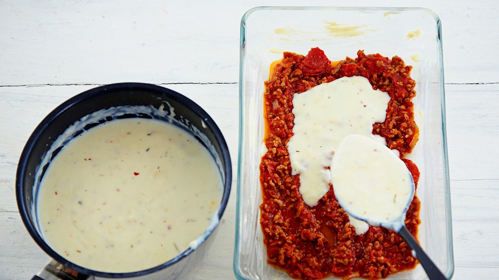 Nostele lasagnevuoan pohjalle 1/4 jauhelihakastiketta ja 1/4 juustokastiketta.