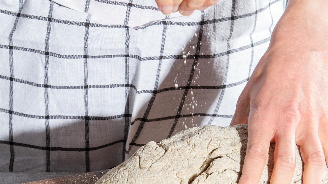 Ravitsemusterapeutti Aino Niemen kädet lähikuvassa vaivaamassa ruisleipätaikinaa.