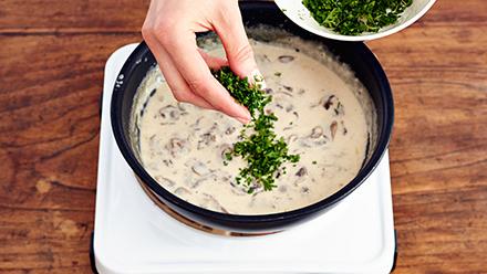 Lisää kerma ja anna kiehahtaa. Hauduta noin 5 minuuttia välillä sekoitellen, kunnes kastike sakenee. Mausta suolalla, pippurilla ja yrttisilpulla.