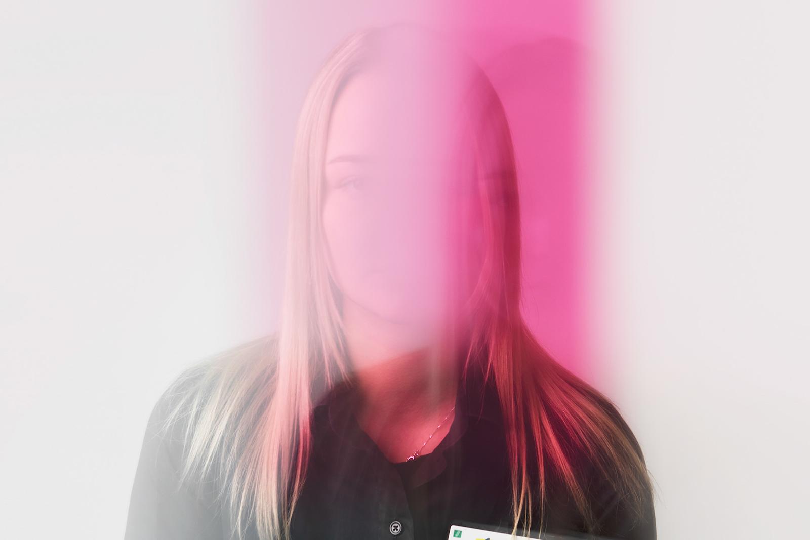 Henkilö, jonka kasvot on sumennettu pinkillä.