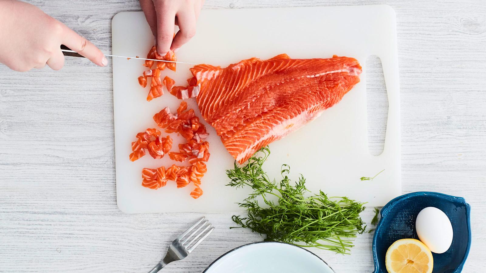 Ota toiseen käteen iso veitsi. Laita se kapeassa päässä lihan ja nahan väliin. Työnnä leveään päähän nahan reunaa pitkin niin, että nahka leikkautuu pois. Leikkaa lohifilee pieniksi kuutioiksi.