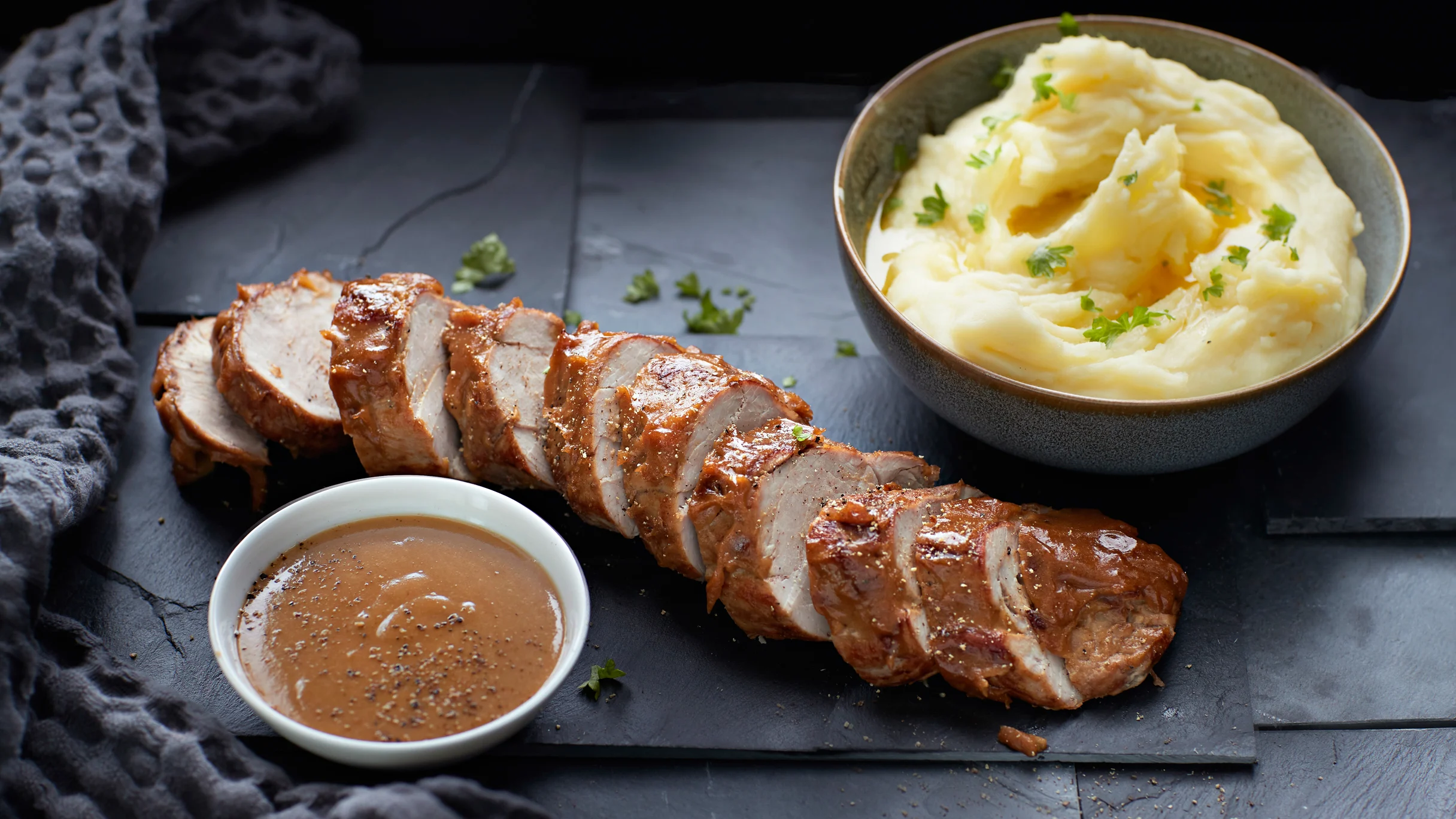 Porsaan sisäfilee viipaloituna ja kulhossa hedelmäinen kermakastike