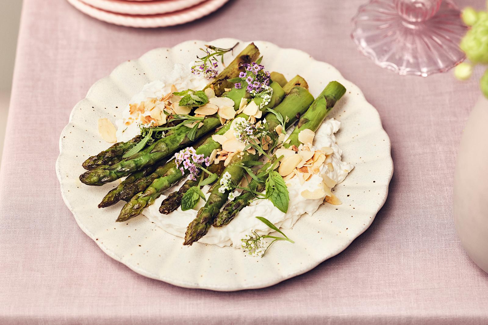 Paistetut tankoparsat vegaanisen juustovaahdon päälle aseteltuna ja mantelilastuilla koristeltuna.