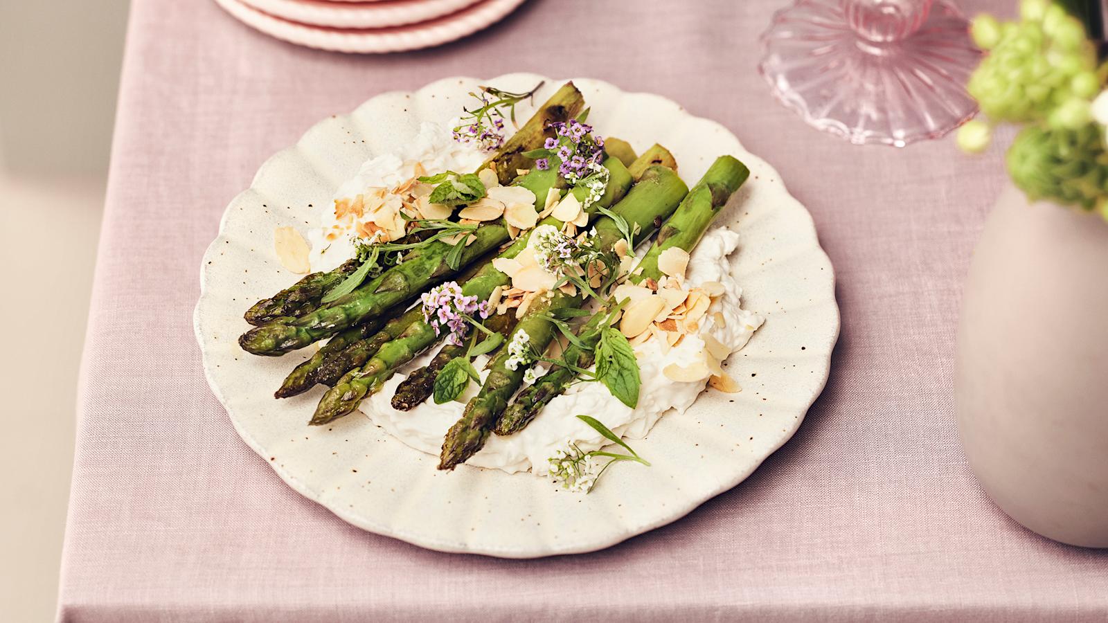 Paistetut tankoparsat vegaanisen juustovaahdon päälle aseteltuna ja mantelilastuilla koristeltuna.