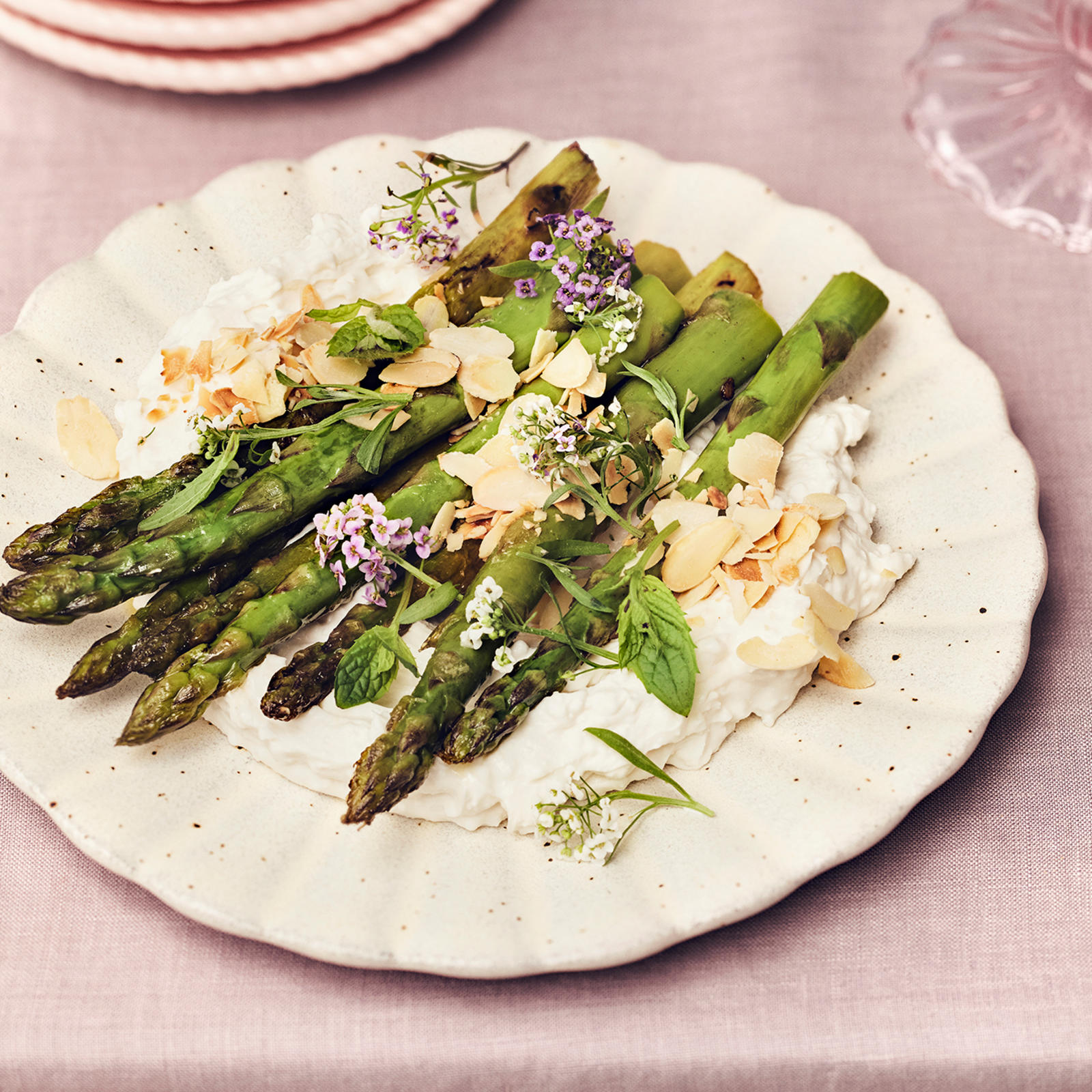 Paistetut tankoparsat vegaanisen juustovaahdon päälle aseteltuna ja mantelilastuilla koristeltuna.