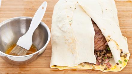 Kääri taikina fileen ympärille niin, että se peittyy. Aseta paketti saumapuoli alaspäin ja nosta uunipellille. Voitele pinta munalla. Paista 200-asteisessa uunissa, kunnes sisälämpötila on noin 60 astetta. Anna fileen levätä hetki ennen leikkaamista.