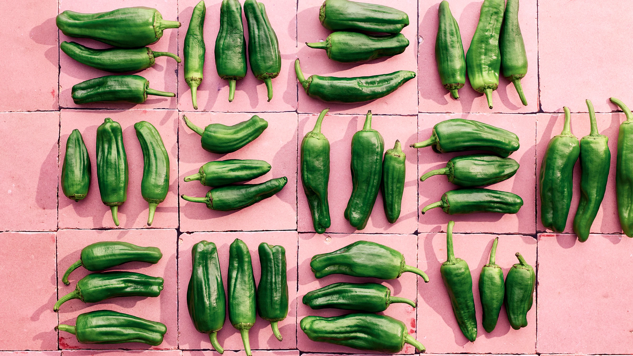 Pimientos de padron -paprikoita vaaleanpunaisella taustalla.
