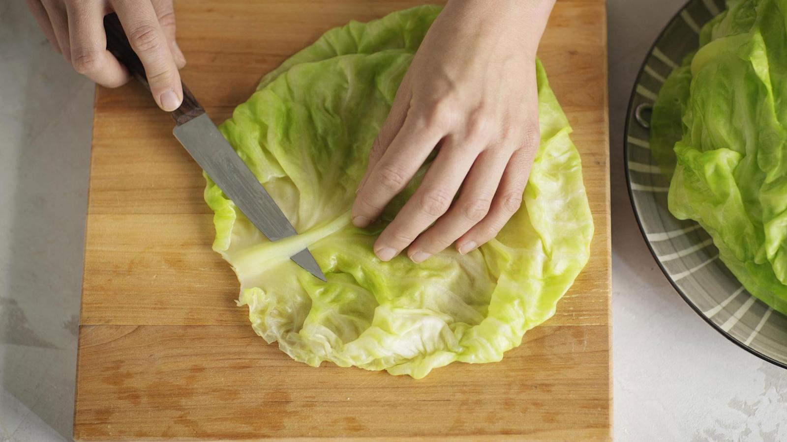 3\. Leikkaa lehdistä paksu kanta pois ja ohenna lehtiruoti, jotta kääriminen sujuu helposti. Silppua ruodit ja pienimmät lehdet hienoksi silpuksi. Keitä 0,5 desiä riisiä tai ohrasuurimoita pakkauksen ohjeen mukaan. Silppua sipuli ja kuullota öljyssä.