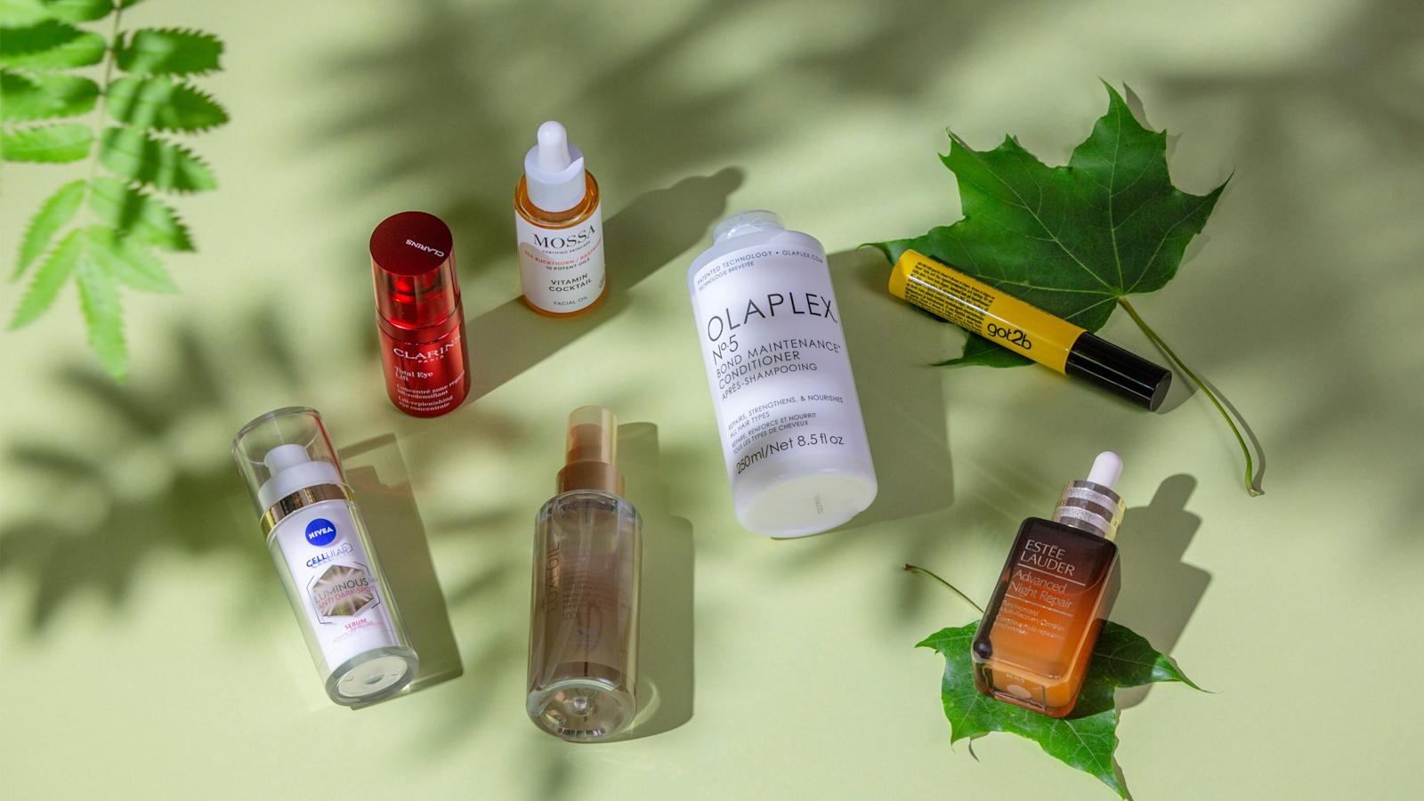 Kesäauringon koetteleman ihon- ja hiustenhoitotuotteita puunoksan varjojen alla.