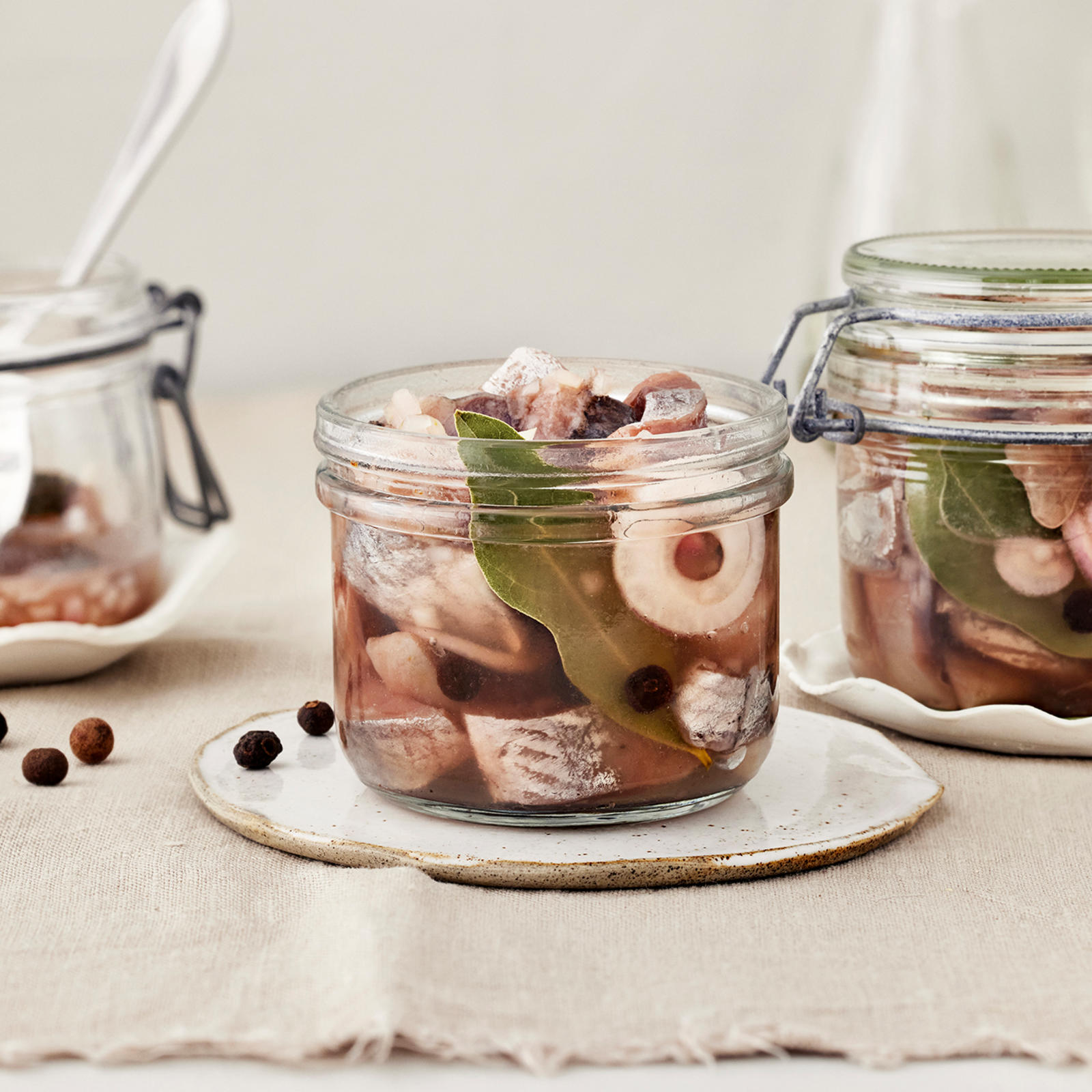 Ranskalaista sipulisiliiä kolmessa lasipurkissa, joista yhdessä haarukka. Purkkien alla vaaleat lautaset. Pöydällä pippureita ja vaalea liina.