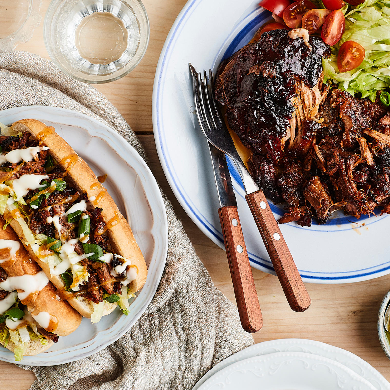 Helppo pulled pork hot dogien täytteenä ja lautasella, jossa salaattia.