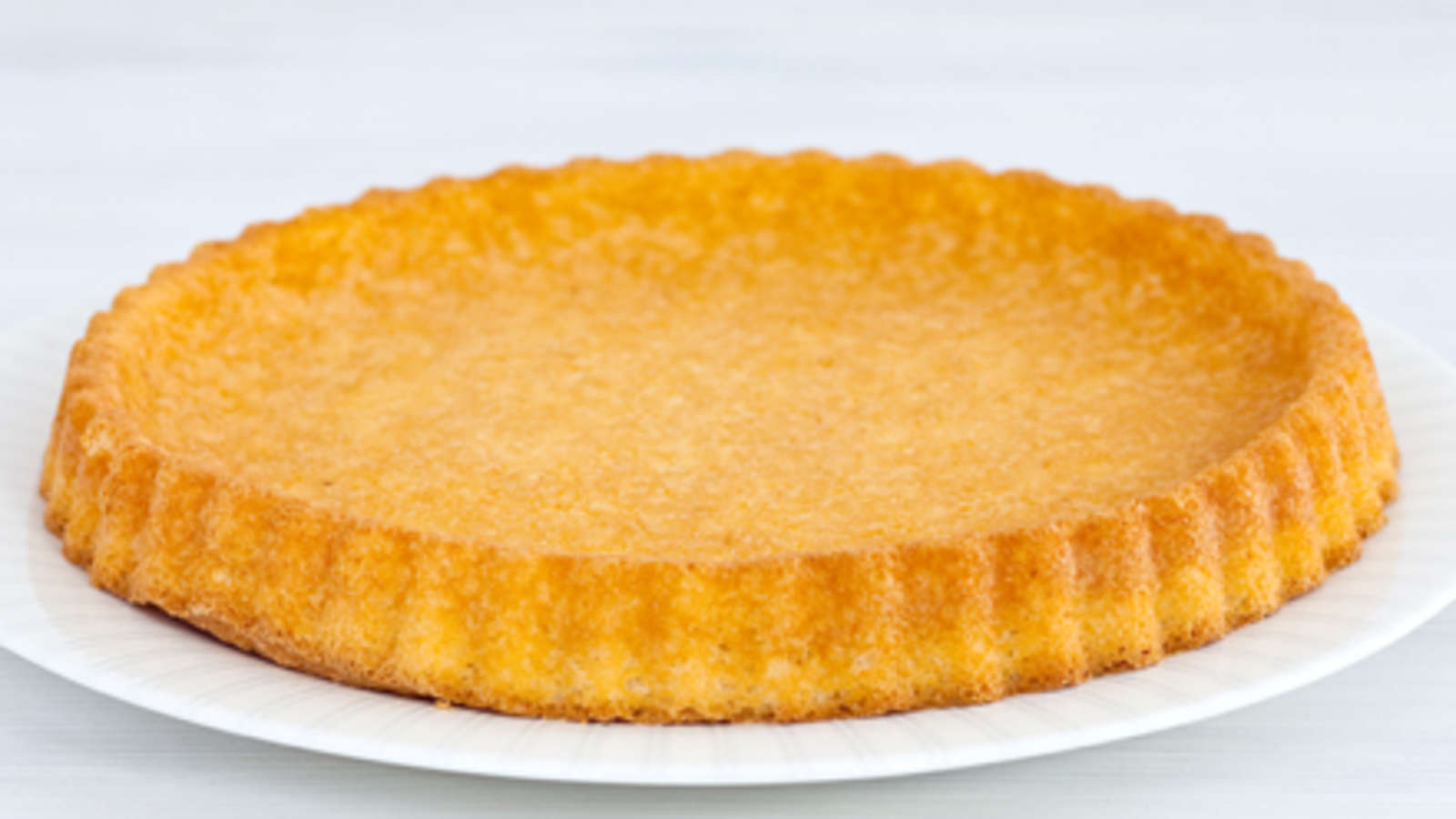 Kuumenna uuni 250-asteiseksi. Aseta torttupohja uuninkestävälle tarjoiluvadille. Pilko puolikohmeiset marjat.