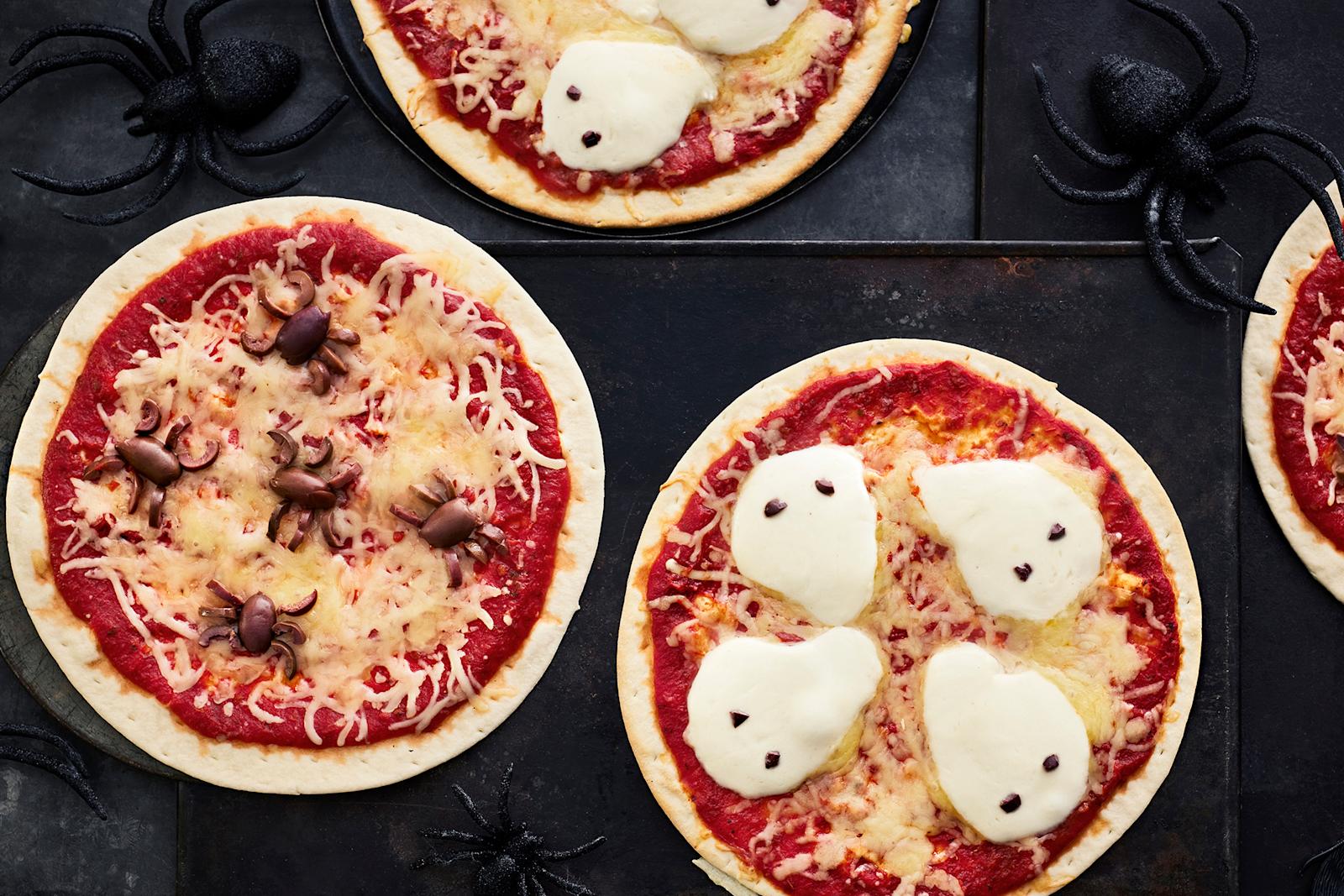 Halloweeniin sopivia pizzoja, joiden päälle asetellut oliivit muistuttavat hämähäkkejä ja mozzarellaviipaleet haamuja.