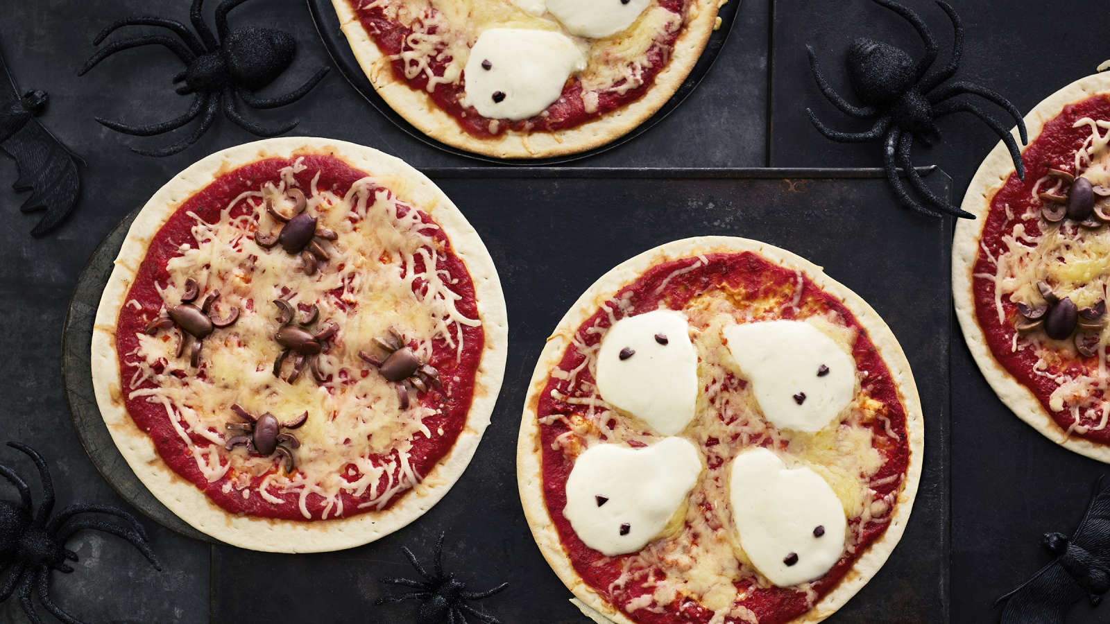 Halloweeniin sopivia pizzoja, joiden päälle asetellut oliivit muistuttavat hämähäkkejä ja mozzarellaviipaleet haamuja.