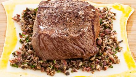 Levitä taikinalevyn keskelle sieniseosta ja nosta päälle filee. Voitele taikinan reunat munalla.