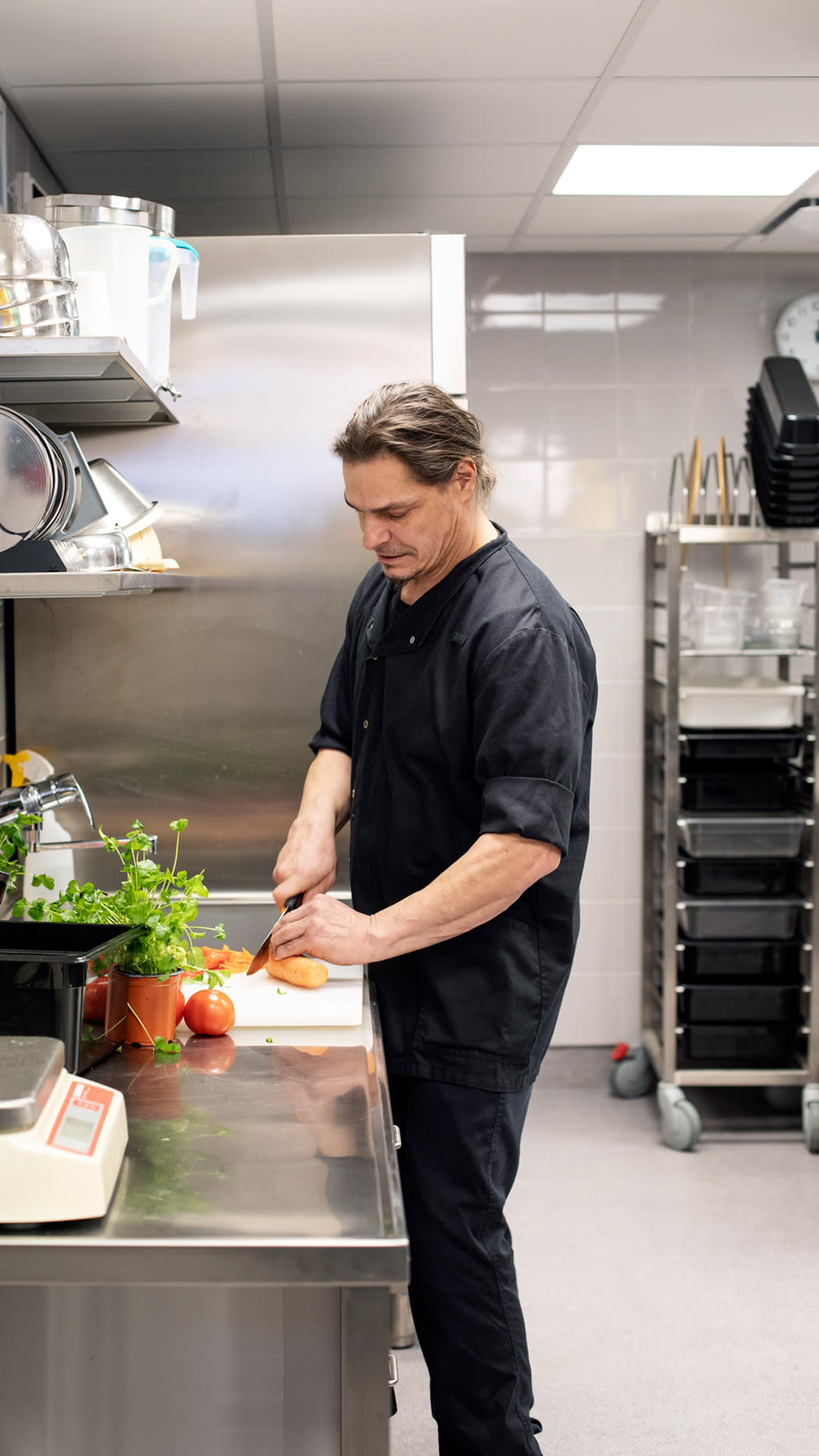 Teppo Vahtera pilkkoo vihanneksia kouluruokalan keittiössä.