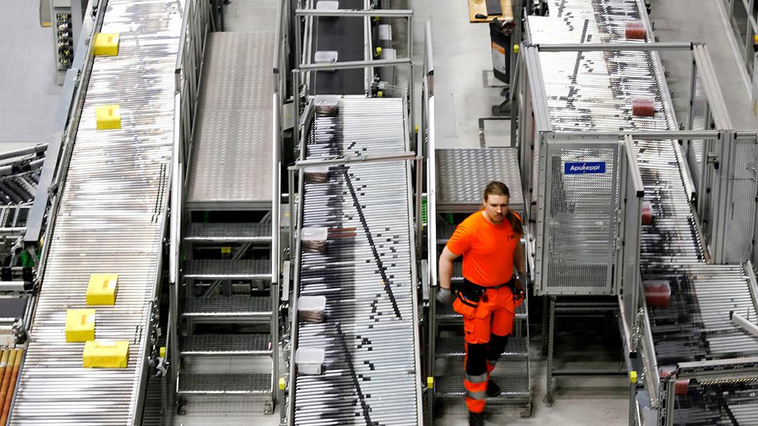 Mies kulkee logistiikkakeskuksen linjojen välissä