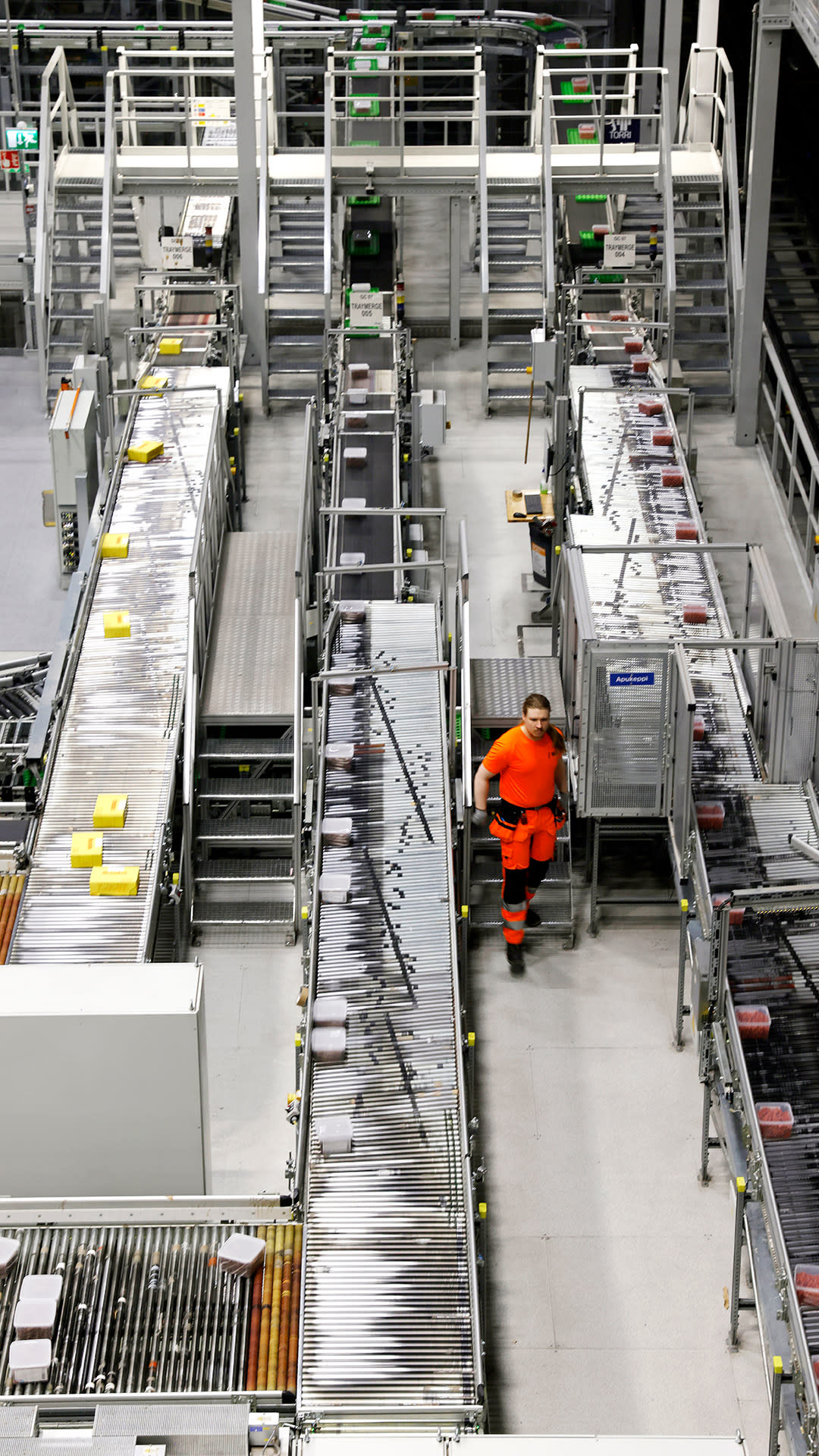 Mies kulkee logistiikkakeskuksen linjojen välissä