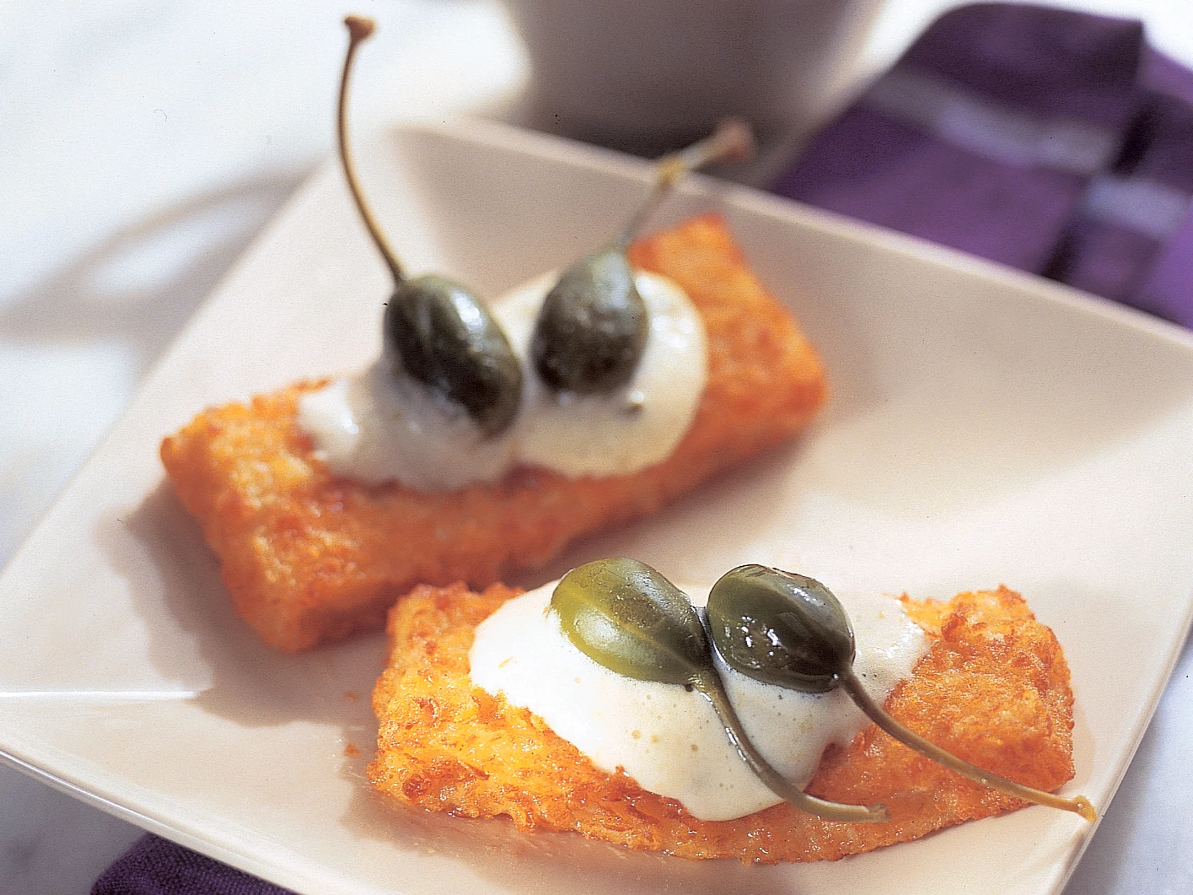 Kalapuikkoja kevyen kapriskastikkeen kera