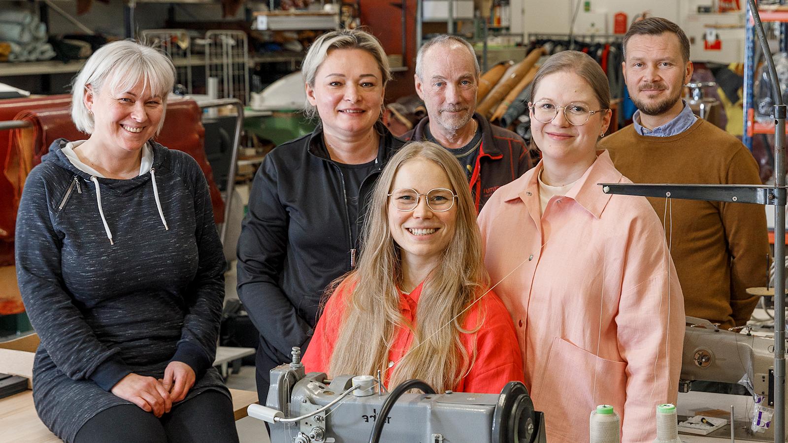 Sastamalan laukkutehtaalla Roosa Mattssonin (punainen asu) ja Sofia Salmen (vaaleanpunaisissa) kanssa kuvassa Irina Belyachkova, Svetlana Blinova, Jouni Mäkinen j Henrik Teckenberg.