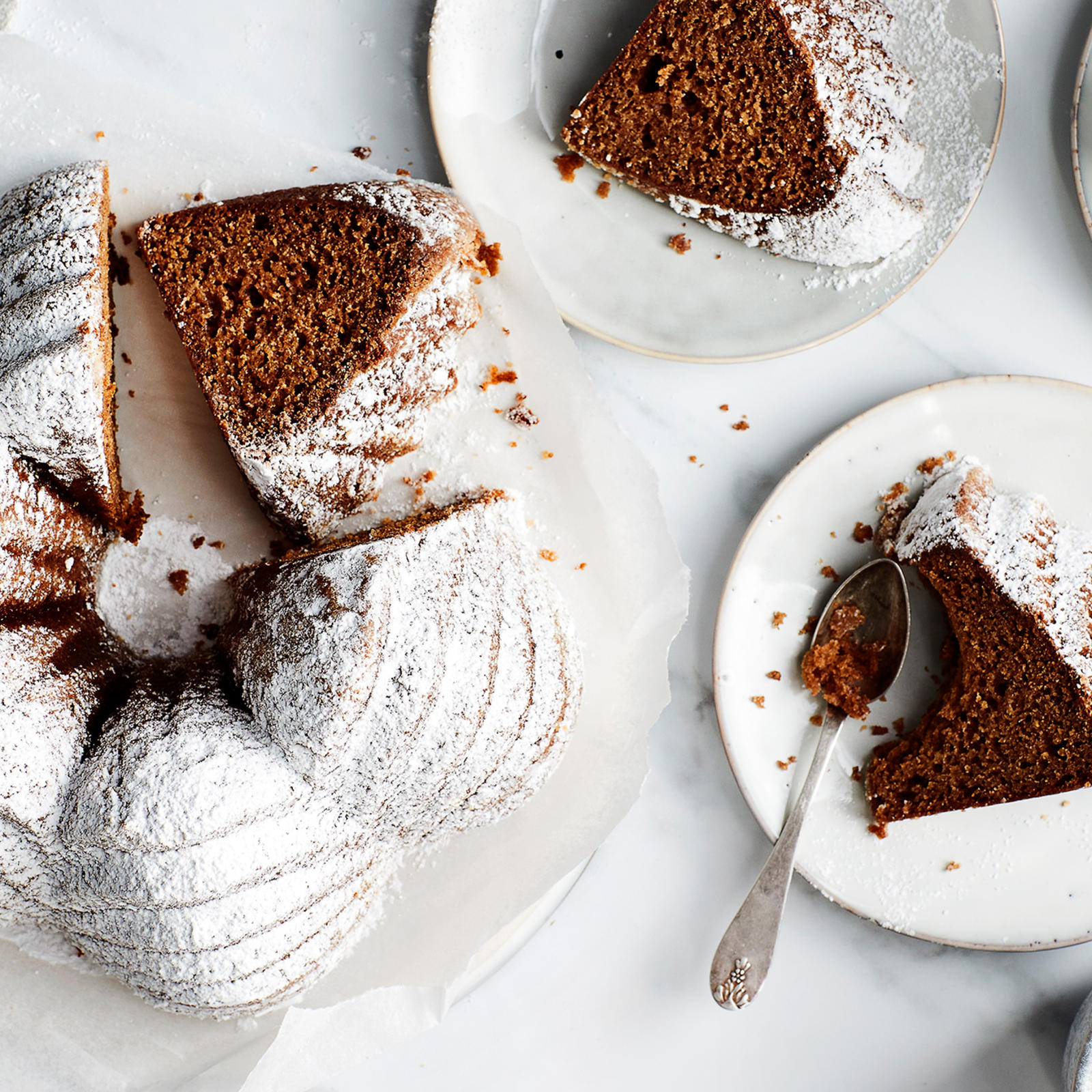 Kakkulautasella on piimäkakku, josta on leikattu pala kahdelle pienelle lautaselle.